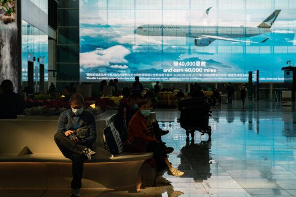 Travelers sit at the arrival hall of the Hong Kong International Airport on in Hong Kong Dec. 30, 2022. (Anthony Kwan/Getty Images)