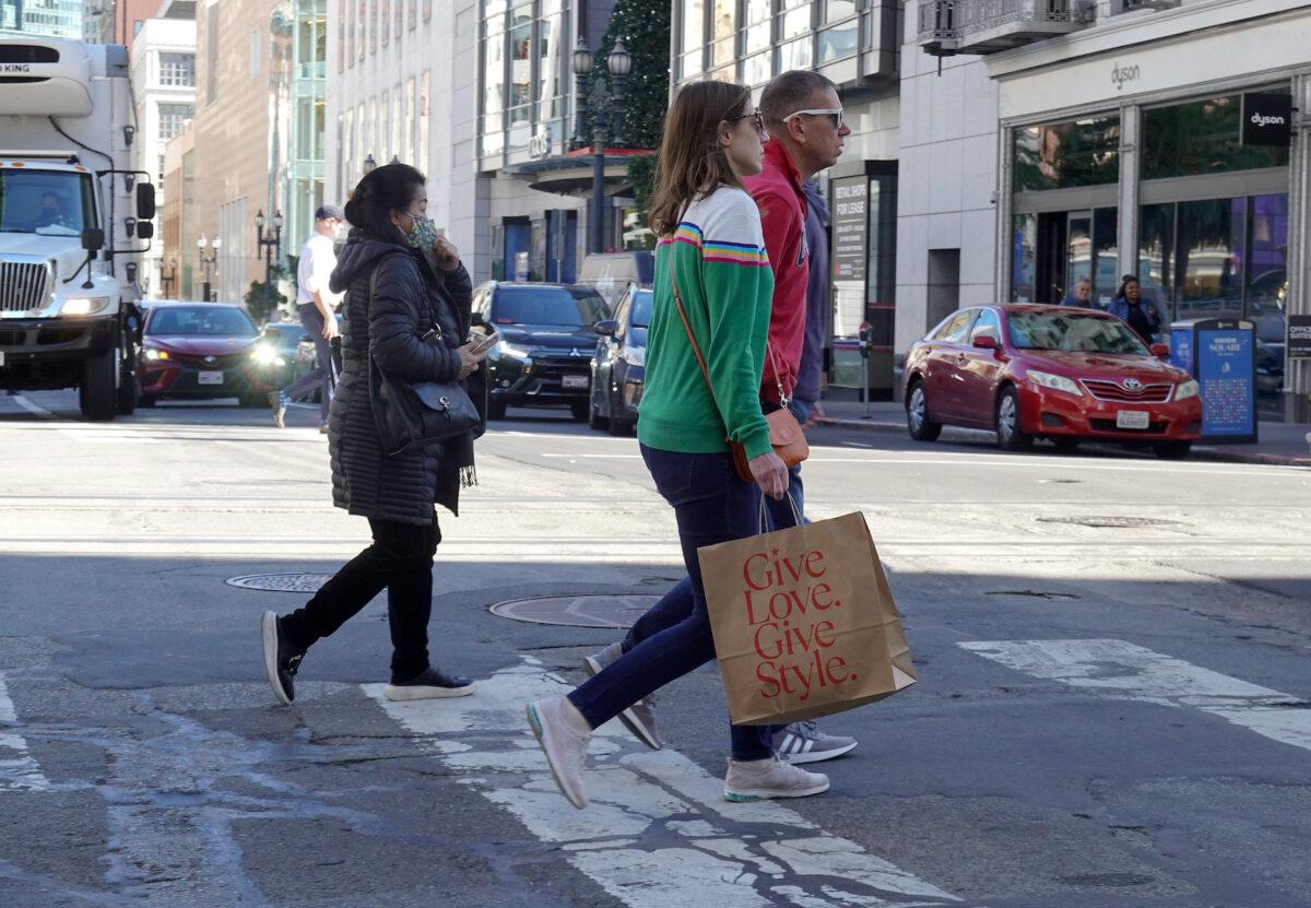 A pedestrian carries a shopping bag while crossing the street in San Francisco on Nov. 16, 2022. (Justin Sullivan/Getty Images)