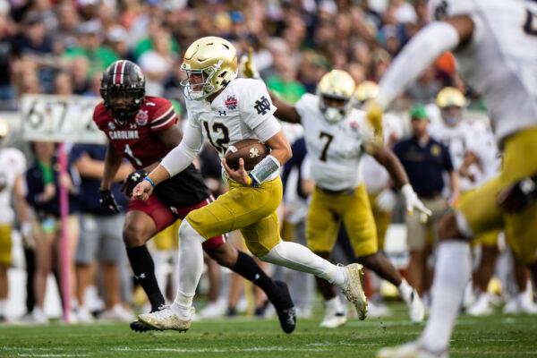 Tyler Buchner (12) of the Notre Dame Fighting Irish rushes for a touchdown during the 1st quarter of the TaxSlayer Gator Bowl against the South Carolina Gamecocks at TIAA Bank Field in Jacksonville, Fla. on Dec. 30, 2022. (James Gilbert/Getty Images)
