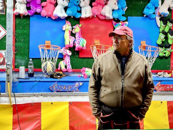 A game vendor waits for customers during the annual New Year's Eve Boot Drop in Prescott, Ariz., on Dec. 31, 2022. (Allan Stein/The Epoch Times)