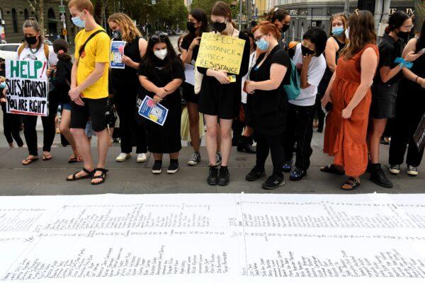 People look at a petition during a "March 4 Justice" rally against sexual violence in Melbourne, Australia on Feb. 27, 2022. (William West/AFP via Getty Images)