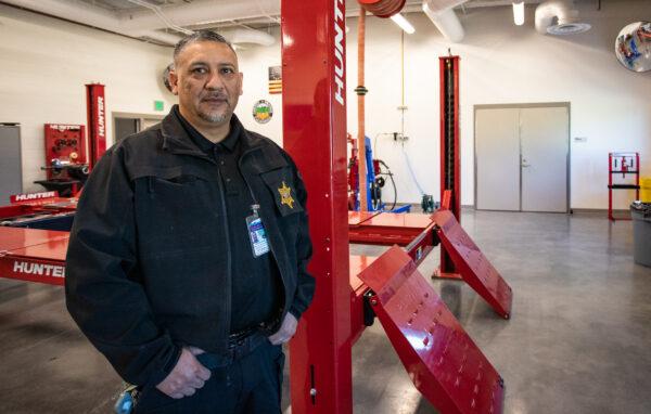 German Zarate stands next to automotive equipment used to train incarcerated men at The County of Orange Probation Department in Orange, Calif., on Jan. 25, 2023. (John Fredricks/The Epoch Times)