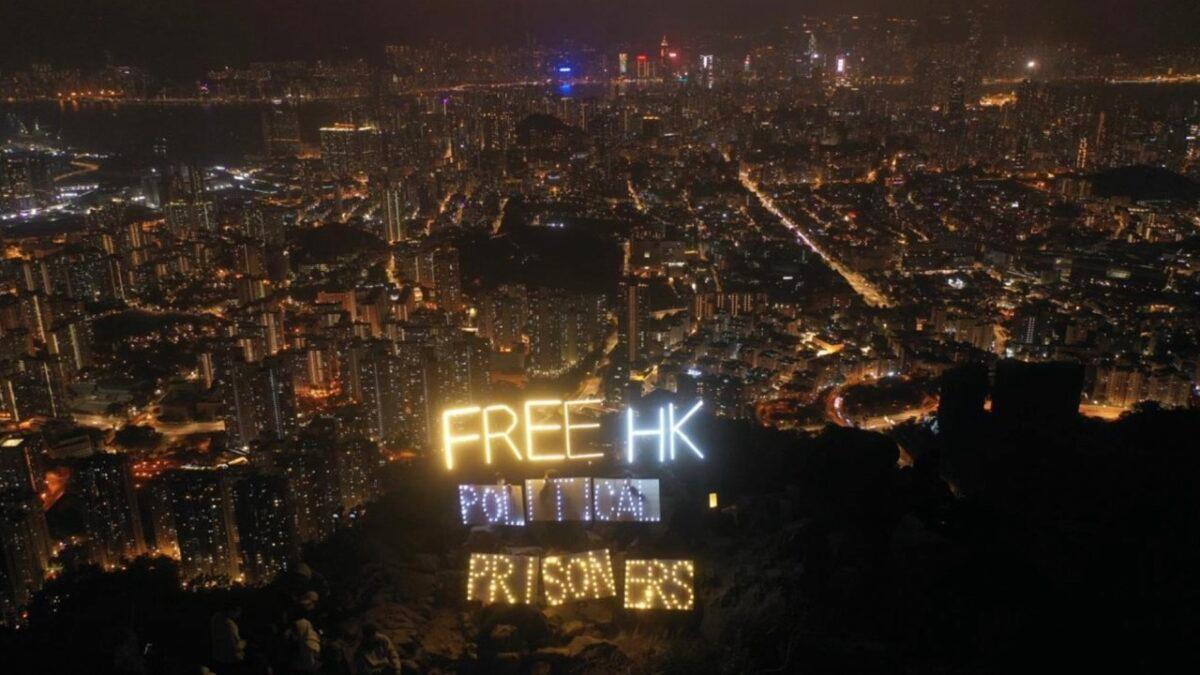 More than a dozen Hong Kong people are holding LED luminaires and electronic candles to display the words "Free HK political prisoners" atop Lion Rock in Hong Kong on Dec. 31, 2022. (Hui Tat/The Epoch Times)