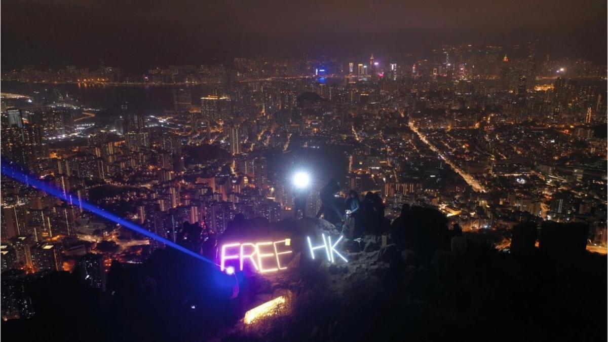 Protestors holding a "Free HK" sign atop Lion Rock in Hong Kong on Dec. 31, 2022. (Hui Tat/The Epoch Times)