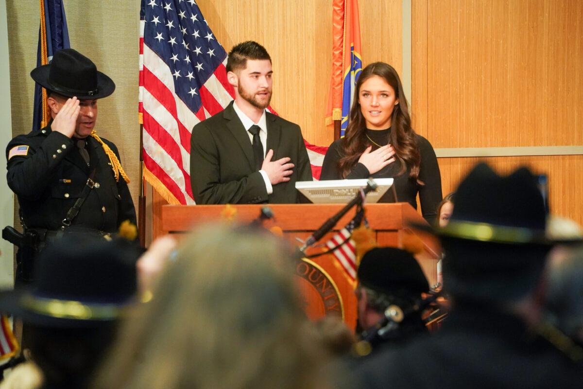 Paul Arteta's two children led the pledge of allegiance at their father's inauguration ceremony for the county's new sheriff at the emergency services center in Orange County, N.Y., on Jan 1, 2023. (Cara Ding/The Epoch Times)