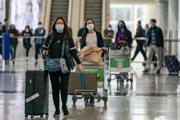 Travelers walk with their luggage at the arrival hall of the Hong Kong International Airport on Dec. 30, 2022. (Anthony Kwan/Getty Images)
