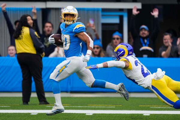 Los Angeles Chargers running back Austin Ekeler (30) evades a tackle from Los Angeles Rams safety Taylor Rapp as he runs toward the end zone for a touchdown during the first half of an NFL football game in Inglewood, Calif., on Jan. 1, 2023. (Mark J. Terrill/AP Photo)