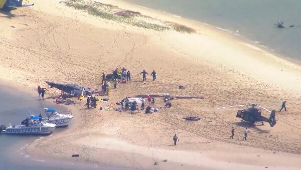 This image made from a video shows sand island island with crashed helicopter, victims and emergency services on Gold Coast, Australia, on Jan. 2, 2023. (CH9 via AP)