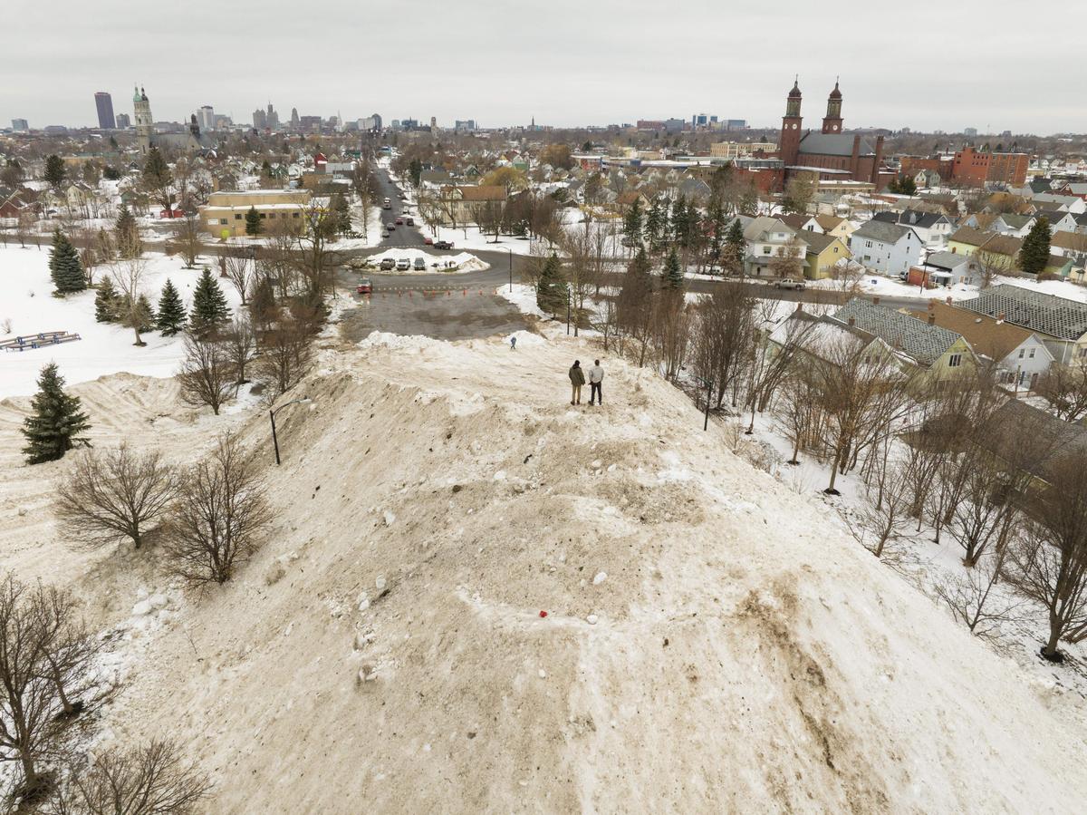 Residents take in the view from atop a gigantic snow pile in front of Central Terminal in Buffalo, New York, on Dec. 29, 2022. (Joed Viera/AFP via Getty Images)