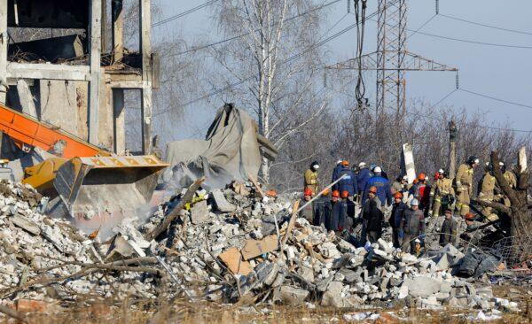 Workers and emergency ministry members remove debris from a destroyed building used as temporary accommodation for Russian soldiers, 63 of whom were killed in a Ukrainian missile strike on Jan. 3, 2023. (Alexander Ermochenko/Reuters)