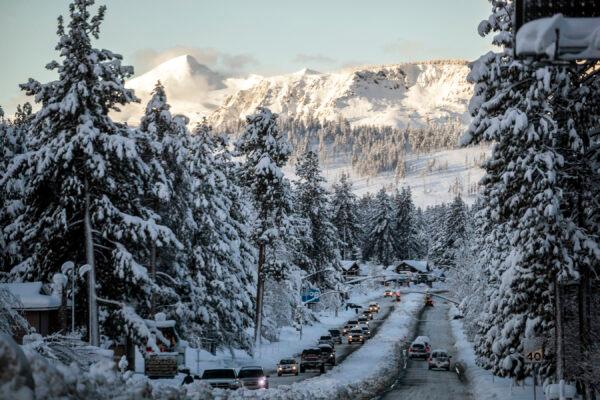 Vehicles travel along a snow-lined U.S. Route 50 the morning after a winter storm pelted the region with a large amount of snow, in South Lake Tahoe, Calif., on Jan. 1, 2023. (Stephen Lam/San Francisco Chronicle via AP)