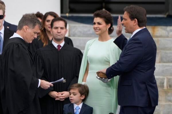 Florida Gov. Ron DeSantis, right, is sworn in by Florida Supreme Court Chief Justice Carlos Muniz, left, to begin his second term during an inauguration ceremony outside the Old Capitol in Tallahassee, Fla., on Jan. 3, 2023. Looking on is DeSantis's wife Casey, second from right, and their son Mason. (AP Photo/Lynne Sladky)