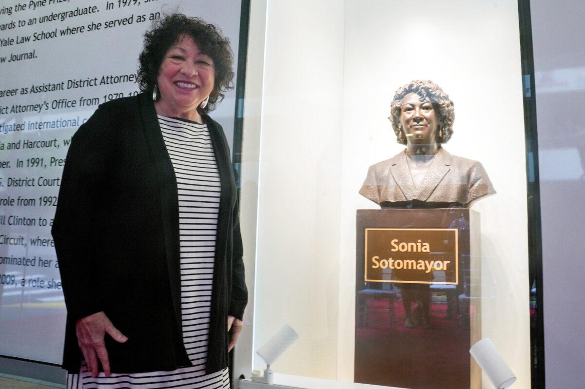 Supreme Court Justice Sonia Sotomayor poses for a photo next to a bronze bust of herself after it was unveiled at the Bronx Terminal Market in New York, on Sept. 8, 2022. (Bebeto Matthews/Pool via Reuters)