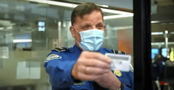 A Transportation Security Administration agent handing back a passenger's driving license at an airport security checkpoint in 2022. (Courtesy of TSA)