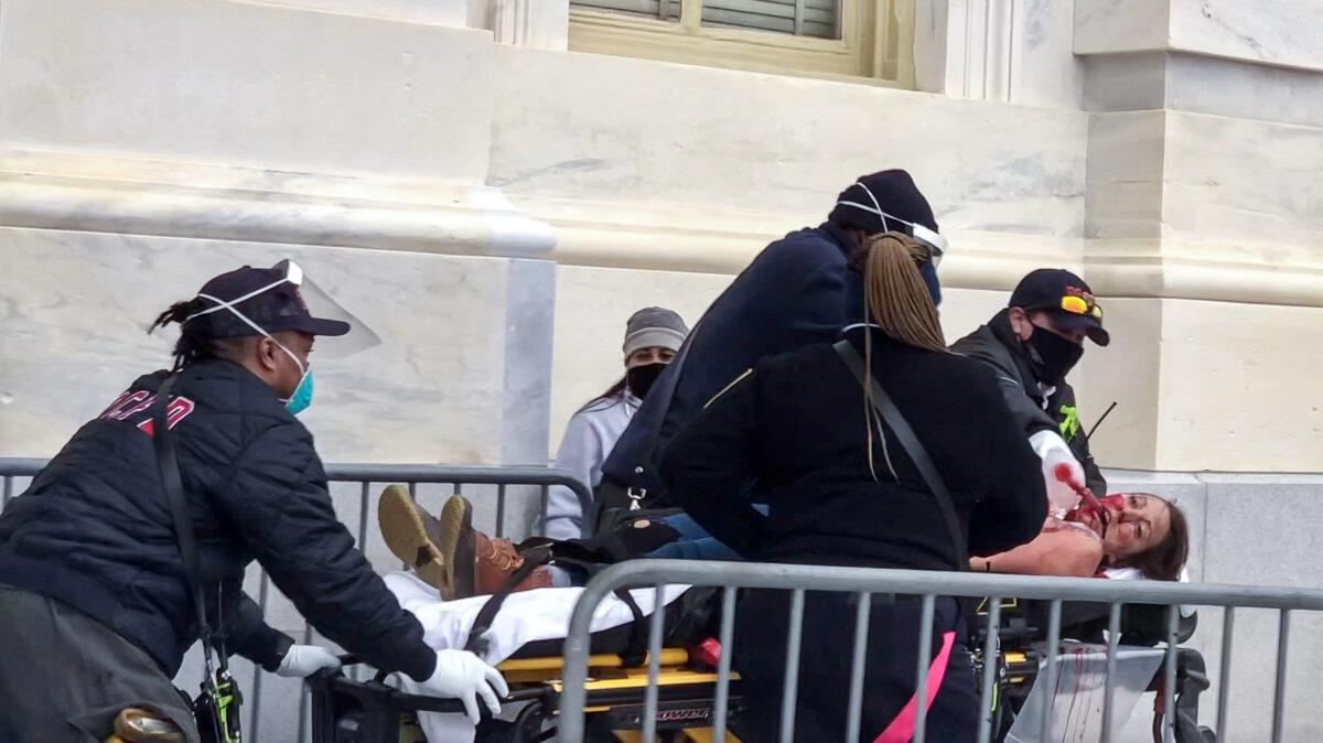 Paramedics from the D.C. Fire and EMS Department perform CPR on protester Ashli Babbitt, who was shot by police near the Speaker's Lobby at the U.S. Capitol on Jan. 6, 2021. She was pronounced dead a short time later. (Steve Baker/Special to The Epoch Times)