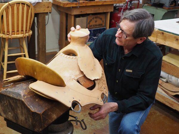 Saddler Cary Schwarz inspects one of his oak leather saddles in his workshop. (Courtesy of Cary Schwarz)