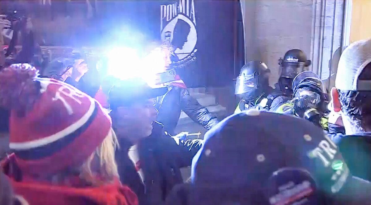A camera flash illuminates a confrontation between protesters and police in the U.S. Capitol on Jan. 6, 2021. (U.S. Department of Justice/Screenshot via The Epoch Times)
