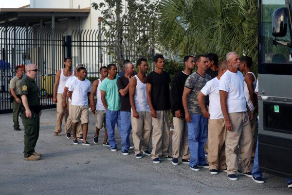 Illegal aliens from Cuba line up to board a bus to be driven to a U.S. Customs and Border Protection station as they are processed in Marathon, Fla., on Jan. 5, 2023. (Joe Raedle/Getty Images)