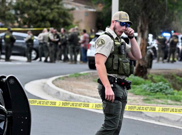 A Riverside County Sheriff's deputy wipes his eye as he stands in Jurupa Valley, Calif. on Dec. 29, 2022. Authorities say a Southern California sheriff’s deputy has been shot during a traffic stop. (Will Lester/The Orange County Register via AP)