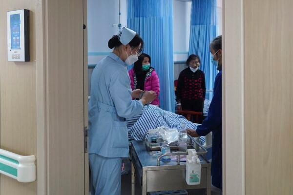 Medical workers check on an elderly patient arriving at an emergency hall in a hospital in Beijing on Jan. 7, 2023. (Andy Wong/AP Photo)