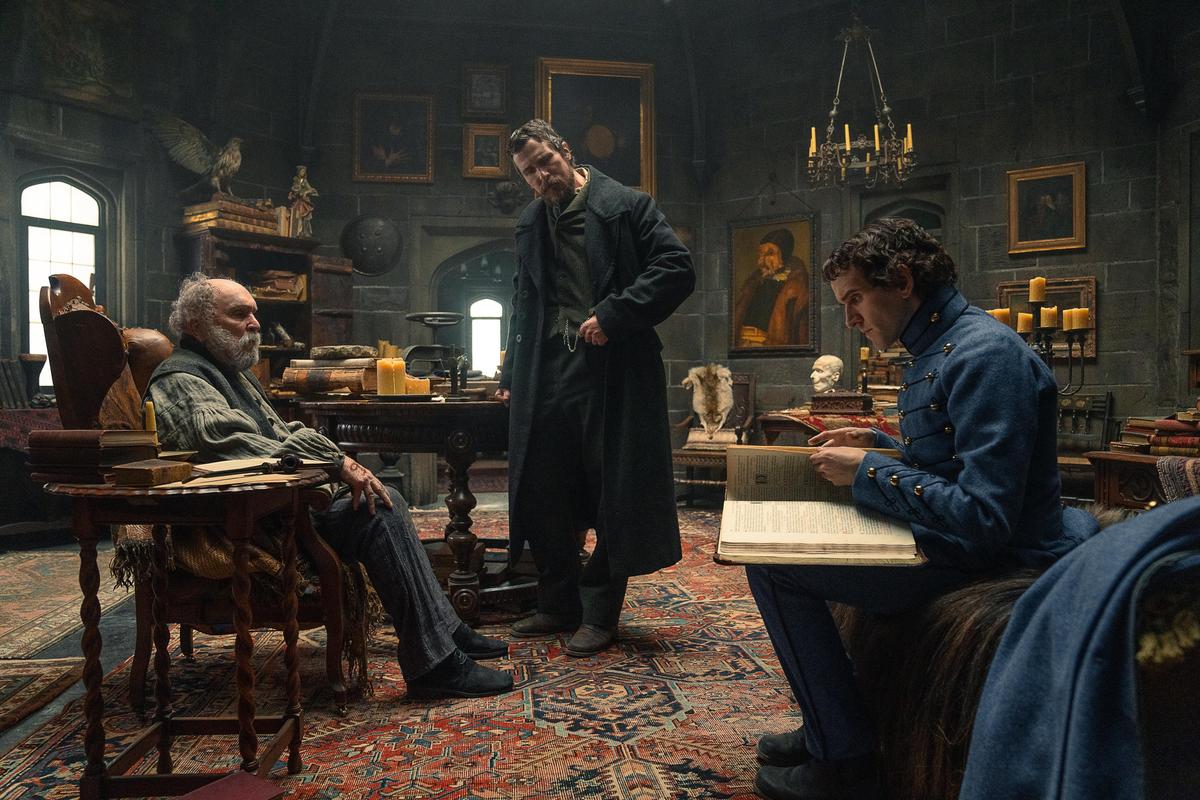 (L–R) Occult scholar Jean-Pepe (Robert Duvall), detective Augustus Landor (Christian Bale), and Cadet Poe (Harry Melling), in "The Pale Blue Eye." (Scott Garfield/Netflix)