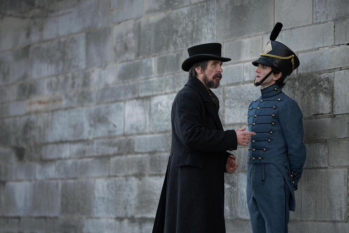 Police detective Augustus Landor (Christian Bale, L) with Cadet Fourth Classman E.A. Poe (Harry Melling), in "The Pale Blue Eye." (Scott Garfield/Netflix)