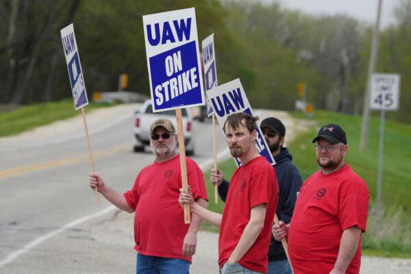 Members of United Auto Workers Local 807 carry picket signs after going on strike at a CNH plant in Burlington, Iowa, on May 2, 2022. (John Loveretta/The Hawk Eye via AP)