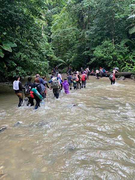 Migrants crossing a river in the jungle of Panama. (Courtesy of Sun Jincai)