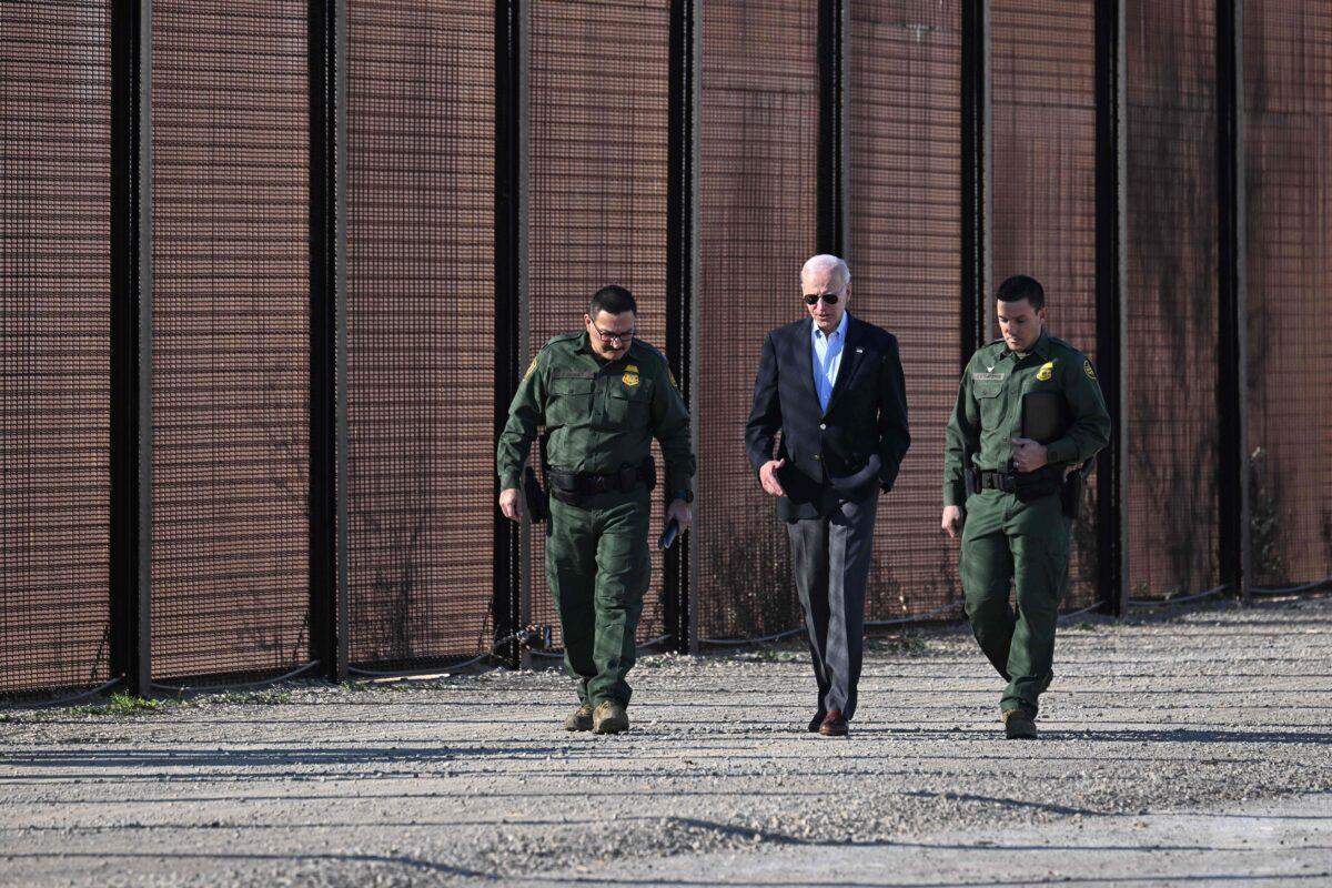 President Joe Biden speaks with a member of the Border Patrol as they walk along the U.S.–Mexico border fence in El Paso, Texas, on Jan. 8, 2023. (Jim Watson/AFP via Getty Images)