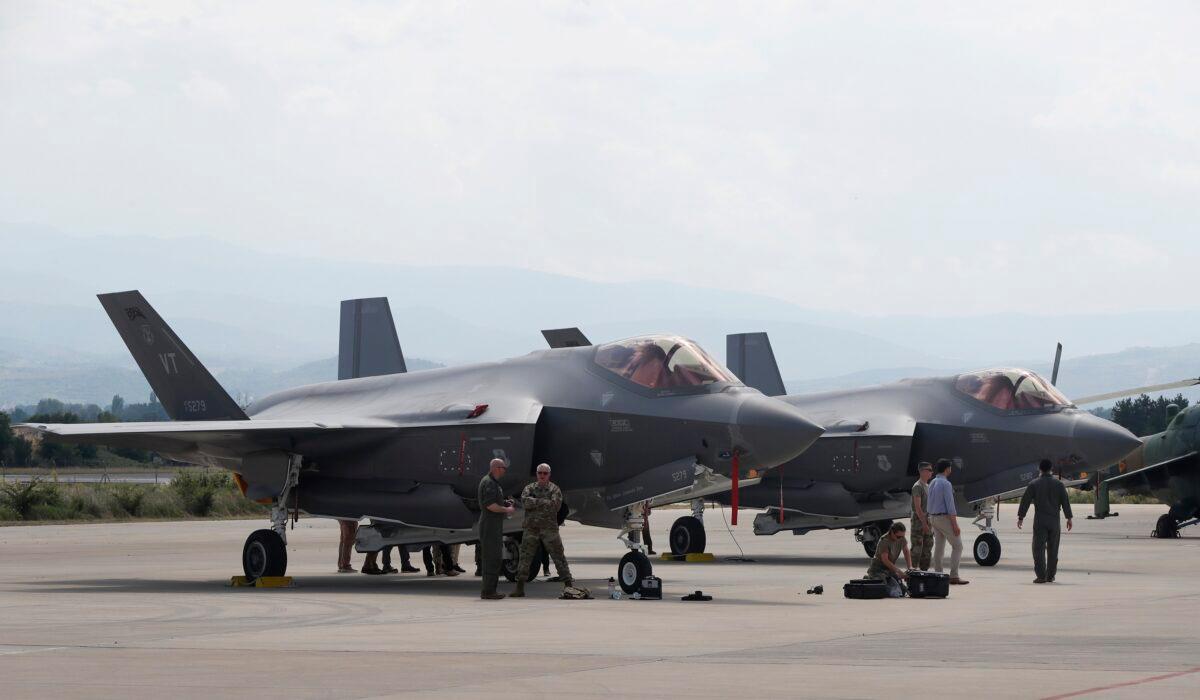 U.S. military personnel work near an F-35 fighter jet of the Vermont Air National Guard, parked in the military base at Skopje Airport, North Macedonia, on June 17, 2022. (Boris Grdanoski/AP Photo)