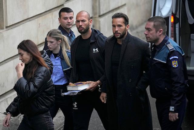 Andrew Tate, third right, and his brother Tristan, second right, are brought by police officers to the Court of Appeal, in Bucharest, Romania, Tuesday, Jan.10, 2023. (AP Photo/Vadim Ghirda)