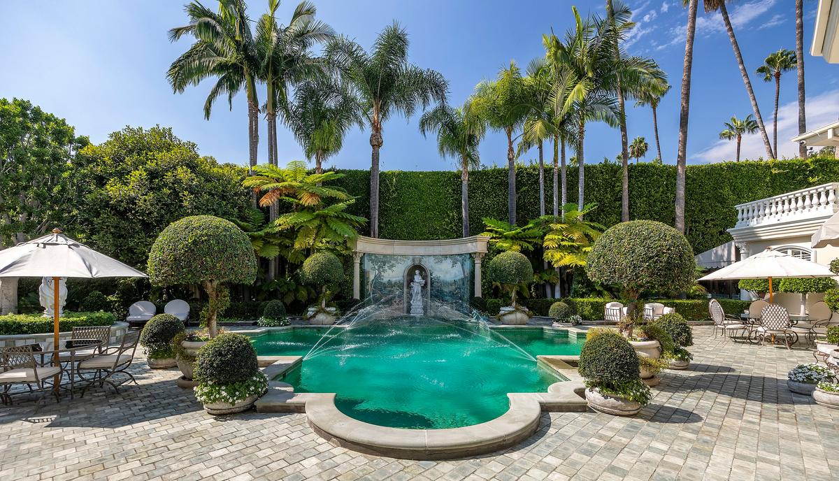 The property's very private pool area with statuary, a fresco, and fountains is a delightful place to entertain guests. (Courtesy of Jade Mills Estates)