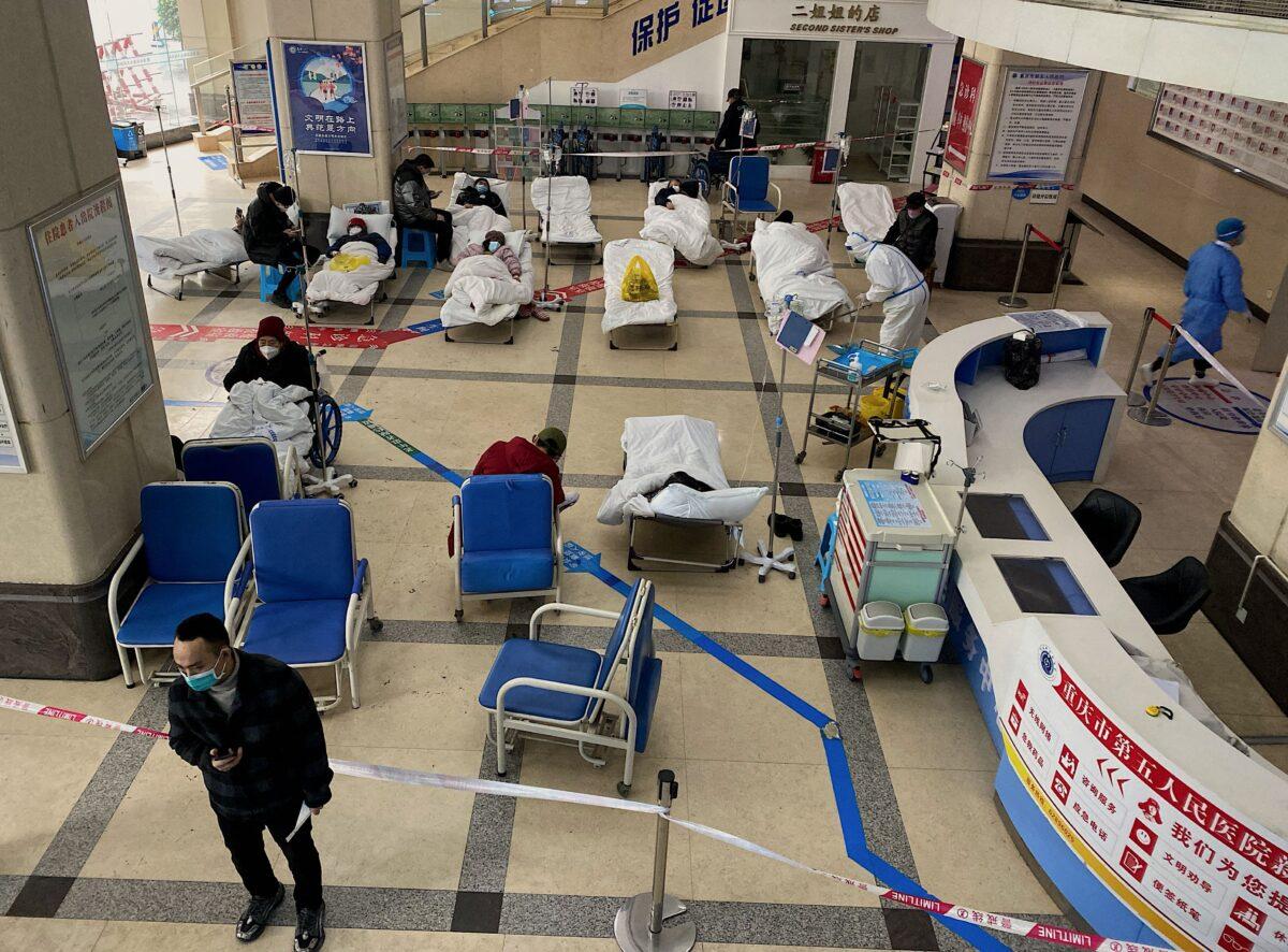 A man stands in front of a cordoned-off area where COVID-19 patients lie on hospital beds in the lobby of the Chongqing No. 5 People's Hospital, in China's southwestern city of Chongqing, on Dec. 23, 2022. (AFP via Getty Images)