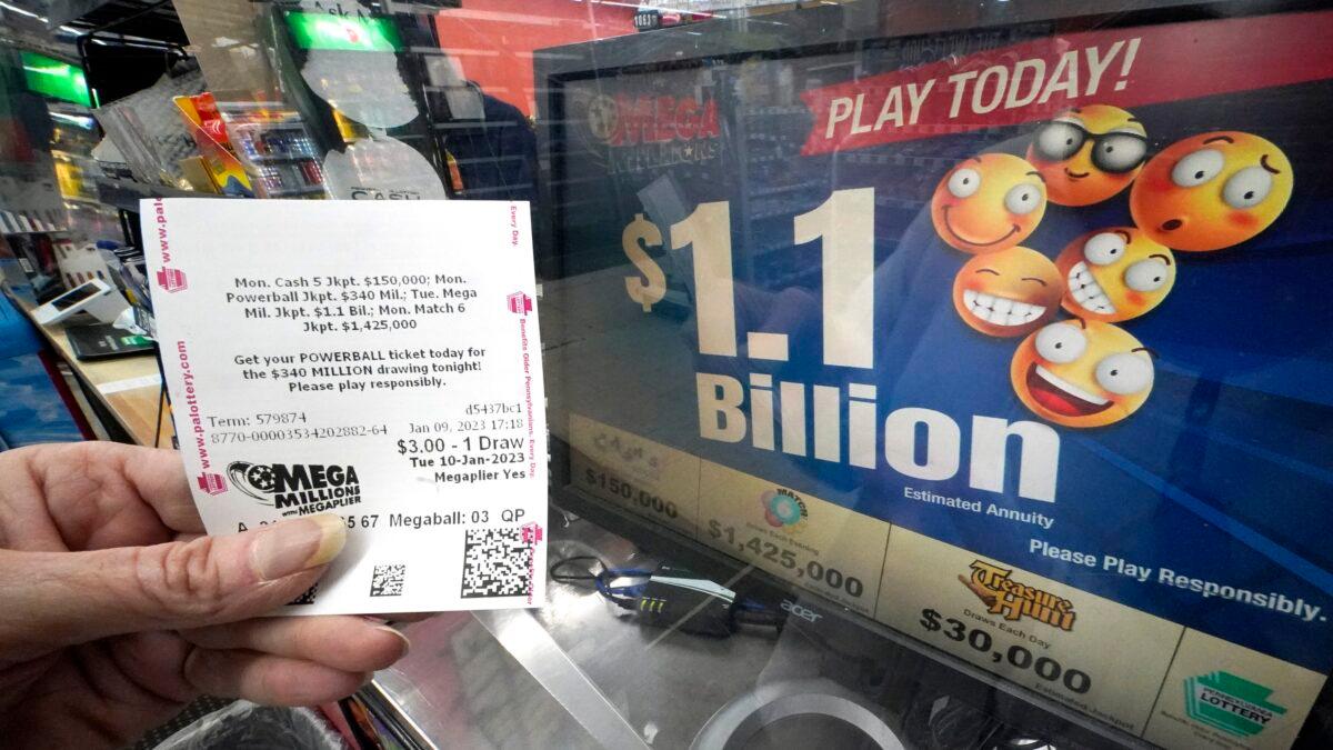 A Mega Millions customer displays her ticket for the estimated jackpot of $1.1 Billion at the Fuel On Convenience Store in Pittsburgh on Jan. 9, 2023. (Gene J. Puskar/AP Photo)