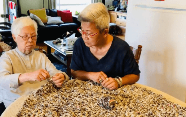 Pamela Leung's 95-year-old mother teaching her to weave for her interactive artwork "Agglomerate" in a photo taken in February 2022. (Courtesy of Pamela Leung)