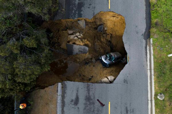 In this image taken with a drone, a vehicle is stuck in a sinkhole in the Chatsworth section of Los Angeles on Jan. 10, 2023. (Jae C. Hong/AP Photo)
