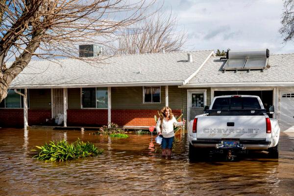 Kim Ochoa leaves her Merced, Calif., home, which is surrounded by floodwaters, as storms continue to batter the state on Jan. 10, 2023. (Noah Berger/AP Photo)