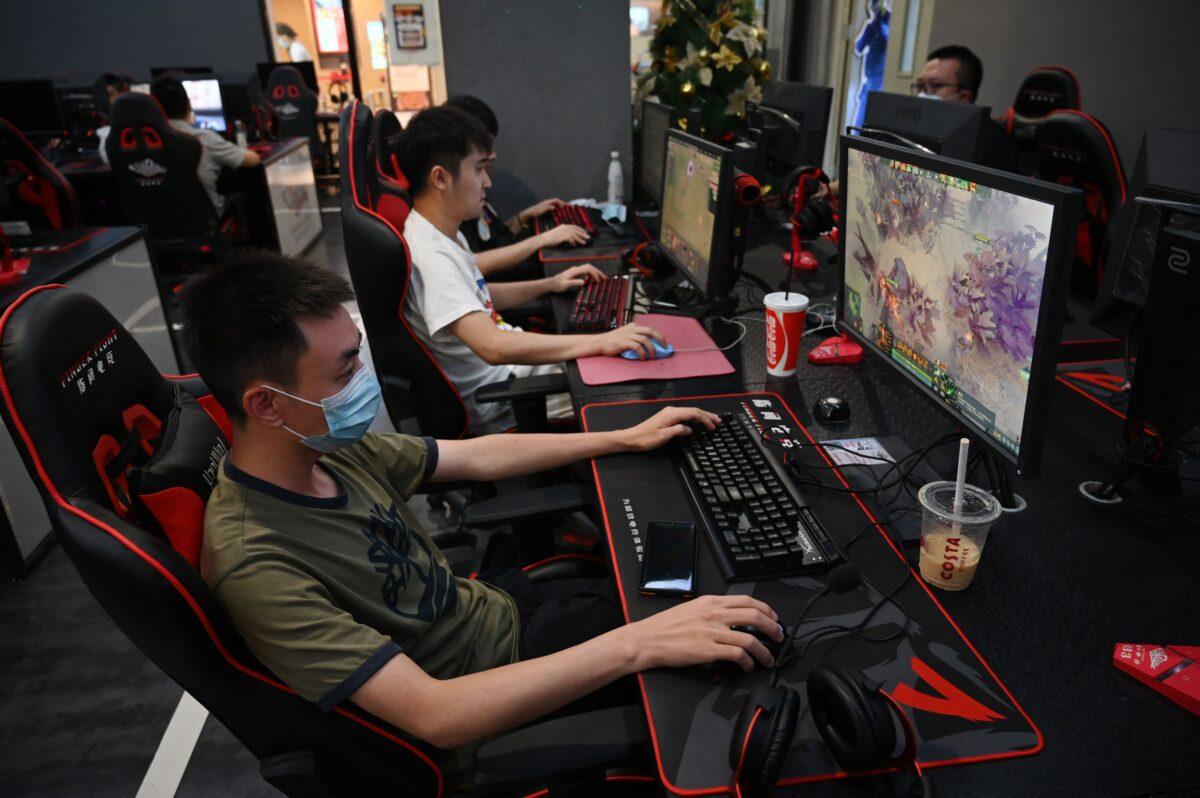 People play computer games at an internet cafe in Beijing on Sept. 10, 2021, days after Chinese officials summoned gaming enterprises, including Tencent and NetEase, the two market leaders in China's multibillion-dollar gaming scene, to discuss further curbs on the industry. (Greg Baker/AFP via Getty Images)