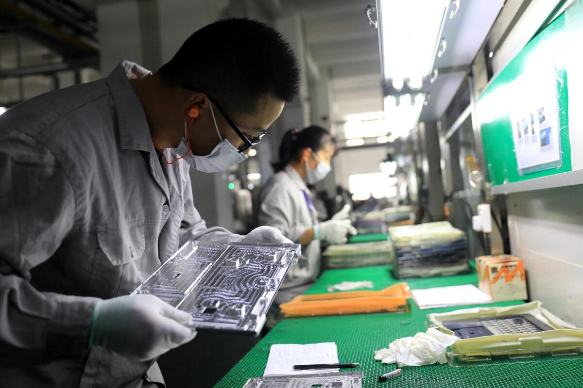 Workers checking laptop parts in a factory in the Hangyong Auto Industrial Park, in Lu'an City, in China's Anhui Province, on Nov. 19, 2018. (STR/AFP via Getty Images)