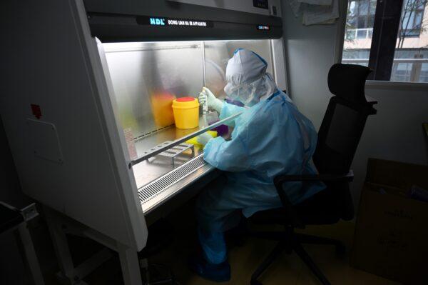 A technician processing samples in a lab at Chinese biotech company Coyote, before testing it in the Flash 20, a machine developed as a fast test for the COVID-19 coronavirus in Beijing, on Sept. 27, 2020. (Greg Baker/AFP via Getty Images)