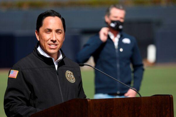 San Diego Mayor Todd Gloria speaks to members of the media as California Gov. Gavin Newsom (back) listens during a press conference at Petco Park in San Diego on Feb. 8, 2021. (Sandy Huffaker/AFP via Getty Images)