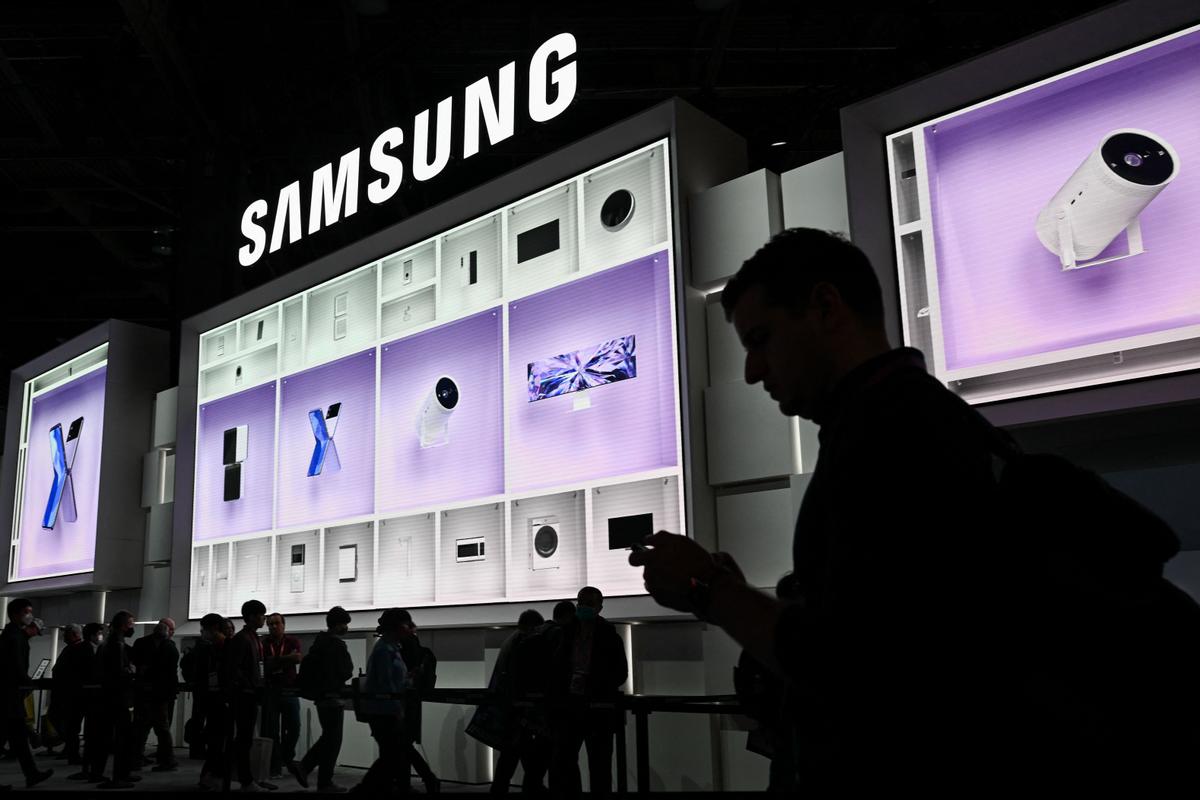 Attendees wait in line beneath a large LED display of smart connected home products to enter the Samsung Electronics booth, during the Consumer Electronics Show (CES) in Las Vegas, Nev., on Jan. 6, 2023. (Patrick T. Fallon / AFP via Getty Images)