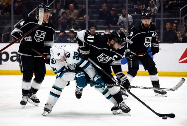 Anze Kopitar (11) of the Los Angeles Kings skates the puck against Logan Couture (39) of the San Jose Sharks in the first period in Los Angeles on Jan. 11, 2023. (Ronald Martinez/Getty Images)