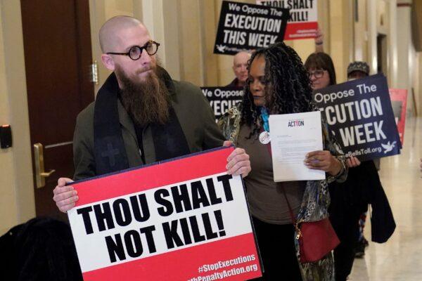 The Rev. Jeffrey Hood of Arkansas (L) and former Oklahoma State Sen. Connie Johnson (R) lead protesters to deliver petitions against the death penalty to the office of Oklahoma Gov. Kevin Stitt in Oklahoma City on Jan. 11, 2023. (Sue Ogrocki/AP Photo)