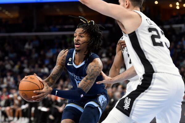 Memphis Grizzlies guard Ja Morant (12) is defended by San Antonio Spurs center Jakob Poeltl (25) and another Spur during the first half of an NBA basketball game in Memphis, Tenn., on Jan. 11, 2023. (Brandon Dill/AP Photo)