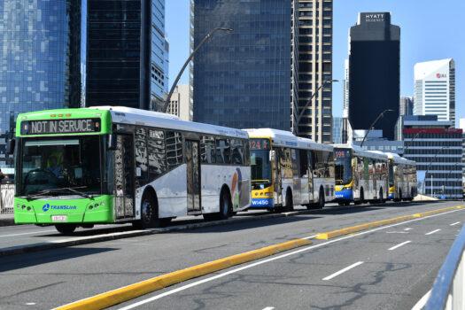 A line of Brisbane City Council Buses are seen driving across the Victoria Bridge in Brisbane, Queensland on Oct. 15, 2021. (AAP Image/Darren England)