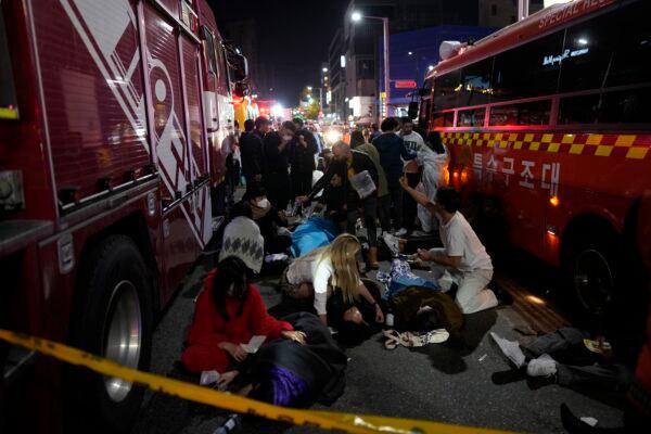 Injured people are helped near the scene of a crowd surge incident in Seoul, South Korea, on Oct. 30, 2022. (Lee Jin-man/AP Photo)