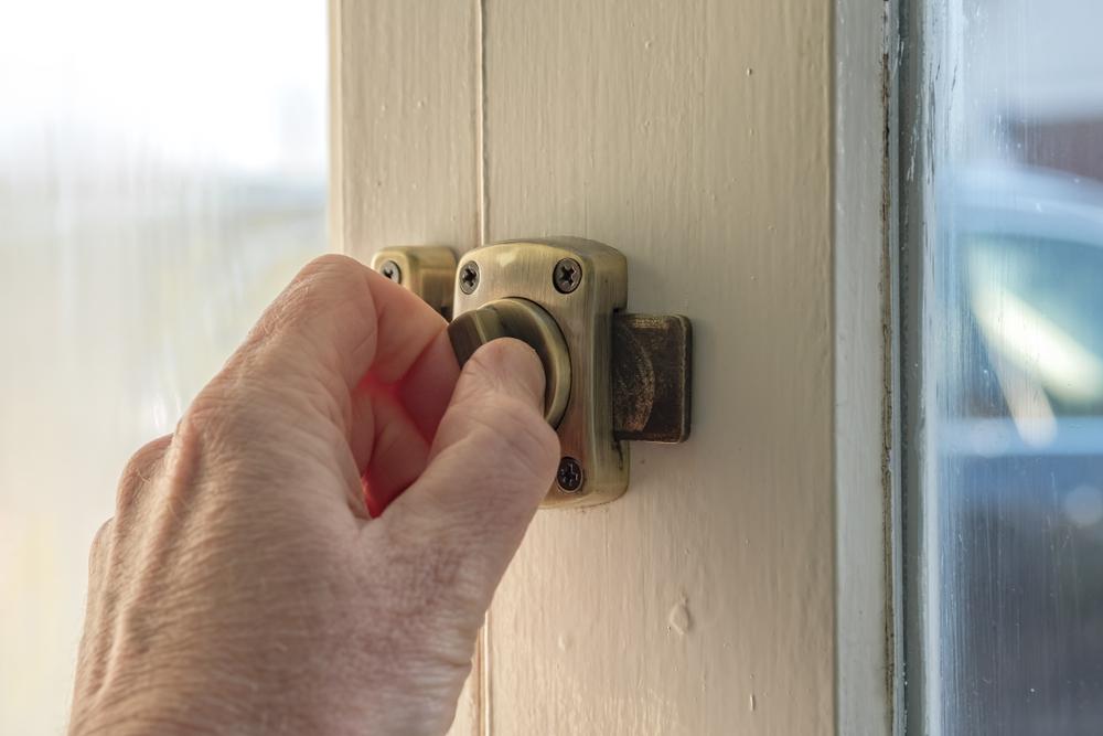 Key and thumbscrew locks are simply small security clamps that attach along the window frame at the position where you want it to stop opening.(Nick Beer/Shutterstock)