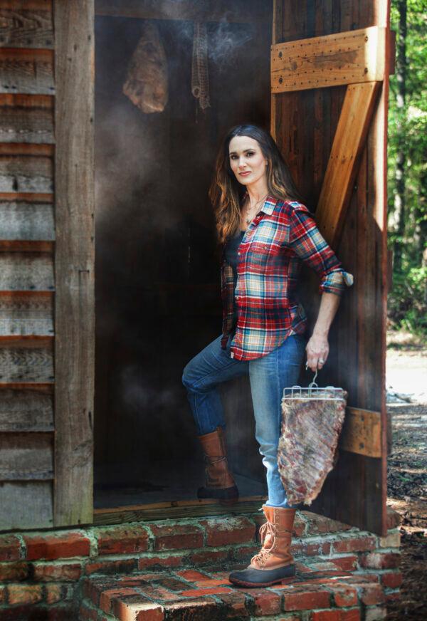Stacy Lyn Harris prepares to carry a rack of ribs from a wild pig into her smokehouse, at her family home outside of Montgomery, Ala. (Graylyn Harris)
