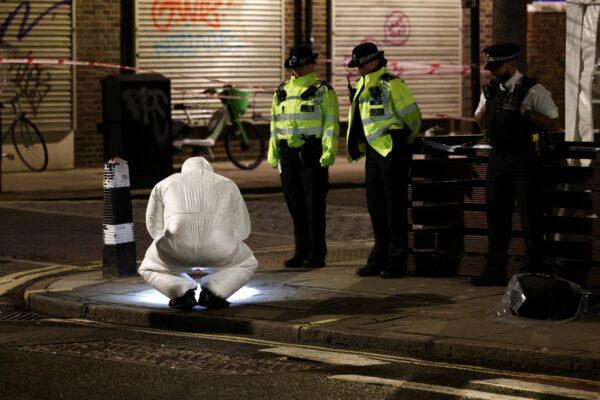 Forensics officers work at the scene of a shooting that reportedly happened during a funeral at St. Aloysius Church, in London, on Jan. 14, 2023. (Henry Nicholls/Reuters)